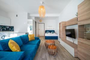 a living room with a blue couch and a television at CASTEL 2 Studio au centre ville de Menton Gare SNCF in Menton