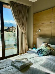 a bedroom with a bed with a large window at New Gudauri Panorama View Loft II in Gudauri