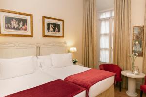 1 dormitorio con cama blanca y manta roja en Casa Romana Hotel Boutique, en Sevilla
