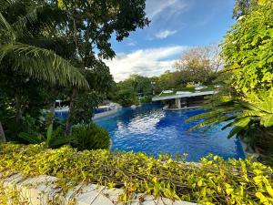 a large swimming pool with a house in the background at 14DC Tambuli Seaside Living in Lapu Lapu City