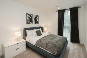 1 dormitorio con 1 cama con mesita de noche y ventana en Stunning 3-Bed Apartment in London, en Londres