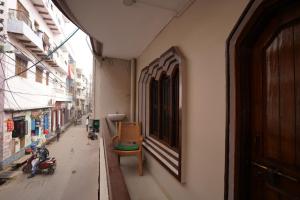 Kashi dham Homestay ( close to Kashi Vishwanath temple and Ghats) في فاراناسي: مدخل مبنى فيه كرسي على شارع