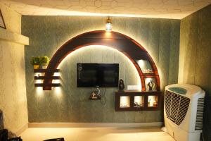 a room with an arched wall with a tv and a fan at Kashi dham Homestay ( close to Kashi Vishwanath temple and Ghats) in Varanasi