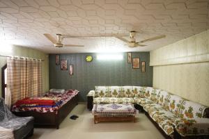 Kashi dham Homestay ( close to Kashi Vishwanath temple and Ghats) في فاراناسي: غرفة معيشة مع أريكة وسرير وسقف +55 صورة