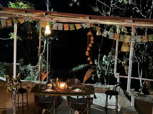 a table and chairs under a pergola at night at The Sweven NeerVan in Rishīkesh