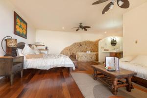 uma sala de estar com duas camas e uma mesa em Issimo Suites (Adults Only) em Manuel Antonio