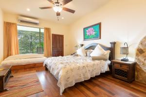 1 dormitorio con 1 cama y ventilador de techo en Issimo Suites (Adults Only), en Manuel Antonio