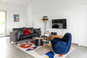 a living room with a couch and a table and chairs at Le Domaine de l'Anse Mitan in Les Trois-Îlets