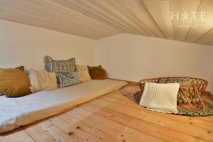 a room with a bed and pillows on a wooden floor at Jolie maisonnette de 60 m2, à quelques pas de la mer in Les Sables-dʼOlonne