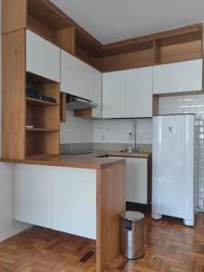 una cucina con mobili bianchi e un frigorifero di Apê na Rua das Palmeiras Imperiais a Rio de Janeiro