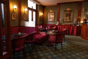 ein Restaurant mit roten Stühlen und Tischen in einem Zimmer in der Unterkunft Hotel Mecenate Palace in Rom