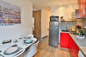 a kitchen with a white table and a refrigerator at Jolie maisonnette de 60 m2, à quelques pas de la mer in Les Sables-dʼOlonne