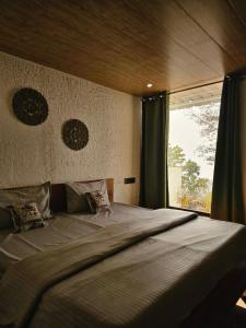 sypialnia z dużym łóżkiem i oknem w obiekcie The Sweven NeerVan w mieście Rishikesh