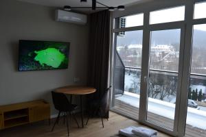 TV in/ali zabaviščno središče v nastanitvi Village apartments Polyana