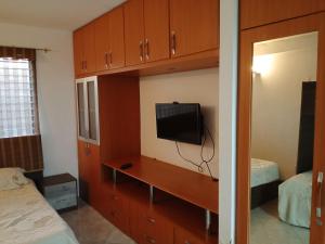 a bedroom with a tv and a cabinet with a bed at Apartamento playero en Lecheria in El Morro de Barcelona