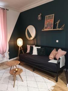 a living room with a black couch and a mirror at Charme et confort en plein centre historique in Nantes