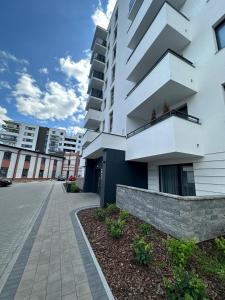 Cet appartement blanc dispose d'un balcon. dans l'établissement Apartament w chmurach, à Toruń