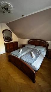 a bedroom with a bed with two pillows and a mirror at Omega Vendégház in Miskolc