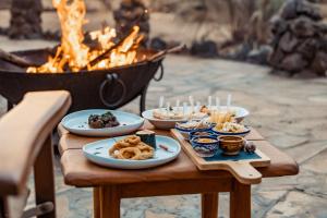 stół z talerzami żywności obok ognia w obiekcie Soroi Larsens Camp w mieście Buffalo Springs  National Reserve