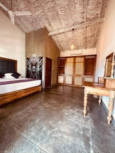 een slaapkamer met een bed en een tafel. bij Dharma Place in Unawatuna