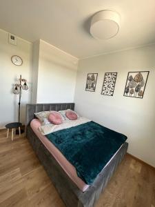 - une chambre avec un grand lit et des oreillers roses dans l'établissement Apartament w chmurach, à Toruń