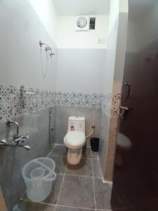 a bathroom with a white toilet in a stall at The Nisarga Residency in Bangalore