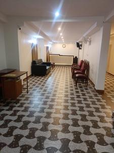 a living room with a piano and chairs in a room at The Nisarga Residency in Bangalore