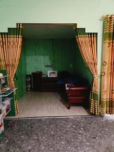 uma sala de estar com paredes verdes e cortinas em homestay mentari em Curup