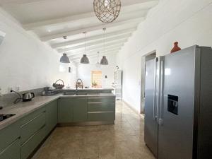 勒迪亚芒Maison à 3 min à pied de la plage的厨房配有绿色橱柜和不锈钢冰箱