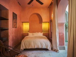 a bedroom with a bed with an arched window at Riad Brummell Medina in Marrakesh