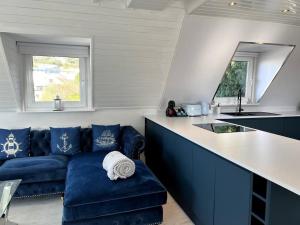 a living room with a blue couch and a kitchen at Luxury Detached House in Torquay Marina in Torquay