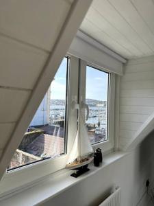 a window with a sail boat on a ledge at Luxury Detached House in Torquay Marina in Torquay