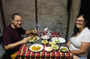 a man and woman sitting at a table with food at Nethmi Homestay & Restaurant in Tangalle