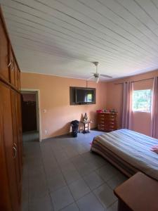 ein Schlafzimmer mit einem Bett und einem TV an der Wand in der Unterkunft Chácara Cuesta Machado in Botucatu