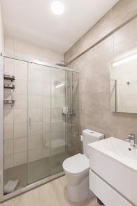 a bathroom with a shower and a toilet and a sink at Faro Guest Apartments in Faro