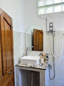 a bathroom with a sink and a mirror at Beach House Cambodia in Koh Rong Sanloem