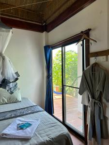 a bedroom with a bed and a sliding glass door at Beach House Cambodia in Koh Rong Sanloem