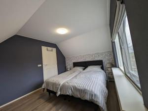 1 dormitorio con cama y ventana grande en Opa's Erf, en Nieuwlande