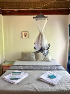 a bed with a canopy with two towels on it at Beach House Cambodia in Koh Rong Sanloem