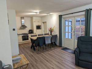 a kitchen and dining room with a table and chairs at Opa's Erf in Nieuwlande
