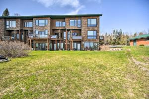 a large brick building with a yard in front of it at Tofte Tranquility Lakefront Townhome with Balcony! in Tofte