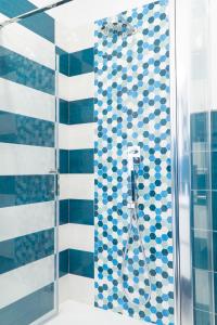 une salle de bain avec douche aux carreaux bleus et blancs dans l'établissement Summer Colors rooms & apartments, à Meta