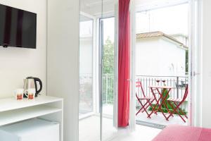 ein Wohnzimmer mit einer Glasschiebetür zu einem Balkon in der Unterkunft Summer Colors rooms & apartments in Meta