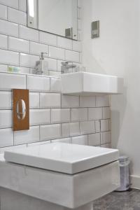a white bathroom with a sink and a toilet at Luxury Central Apartment - Smart TV - Fast WIFI - Near Utilitia Arena in Birmingham