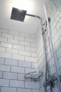a shower in a bathroom with a white tiled wall at Luxury Central Apartment - Smart TV - Fast WIFI - Near Utilitia Arena in Birmingham