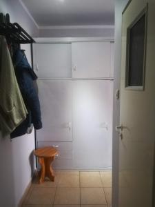 a walk in closet with white cabinets and a stool at Mieszkanie w Centrum in Szczytno