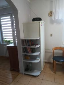 um frigorífico branco num quarto com uma estante de livros em Mieszkanie w Centrum em Szczytno