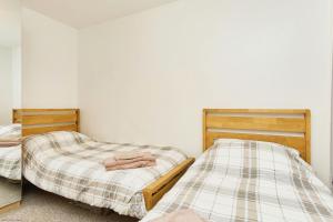 2 aparte bedden in een slaapkamer met een spiegel bij Shanklin Beach - Napier in Shanklin +26 foto's