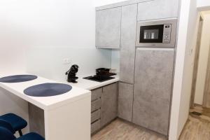 a kitchen with a white counter and a microwave at Berzsenyi Apartmanház in Kaposvár