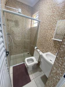 een badkamer met een douche, een toilet en een wastafel bij Pousada Helena e Heloá in Serra Negra